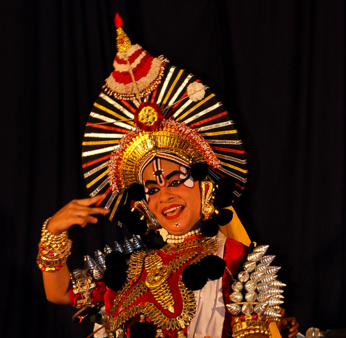 A Theyyam performer in full painted make-up, Kerala